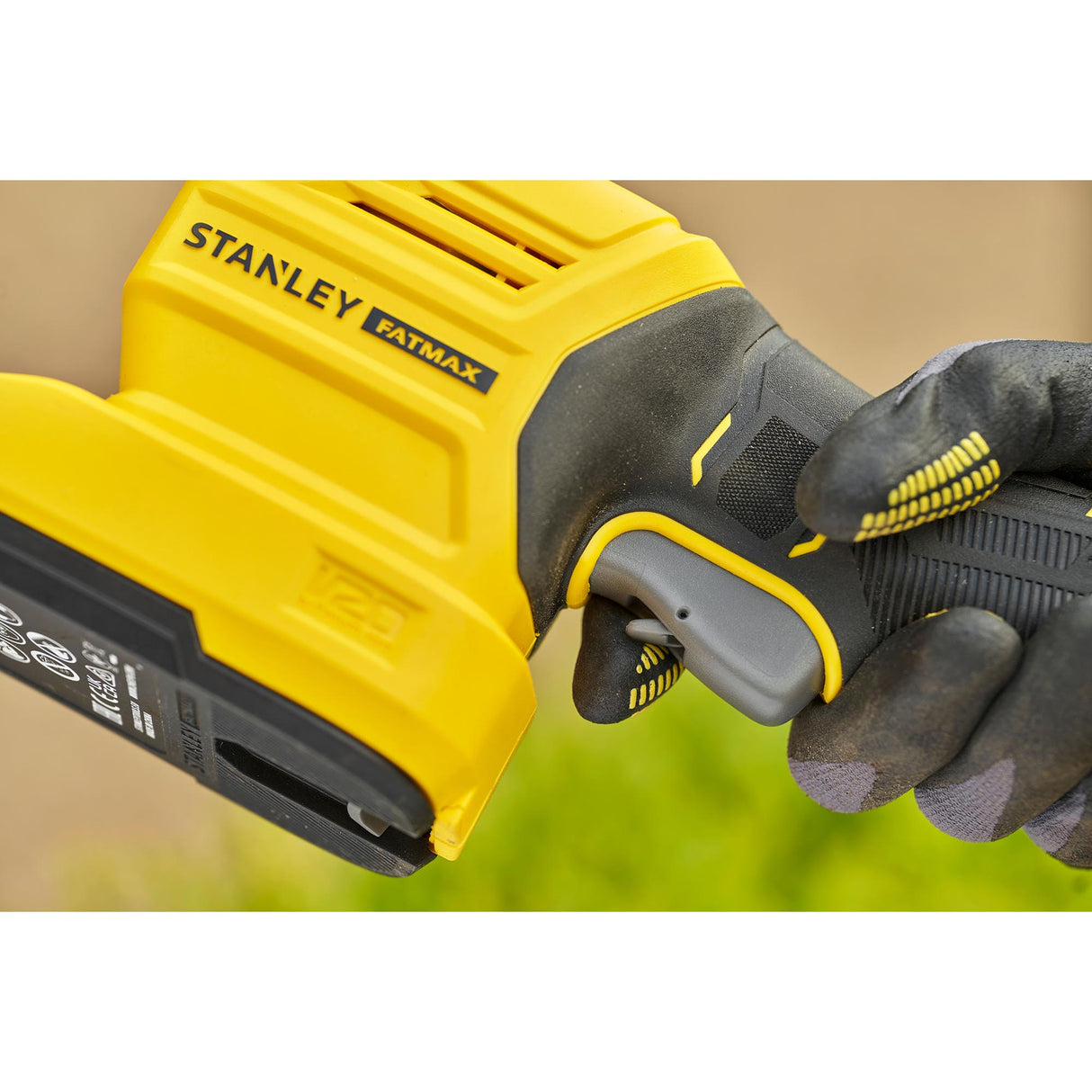 Perceuse visseuse Stanley Fatmax jaune et noire en main, gros plan sur la poignée