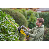 Taille-haie DeWalt jaune, outil de jardinage électrique utilisé pour tailler des haies vertes