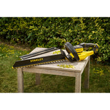 Taille-haie Stanley électrique jaune et noir posé sur une table en bois, outil de jardinage
