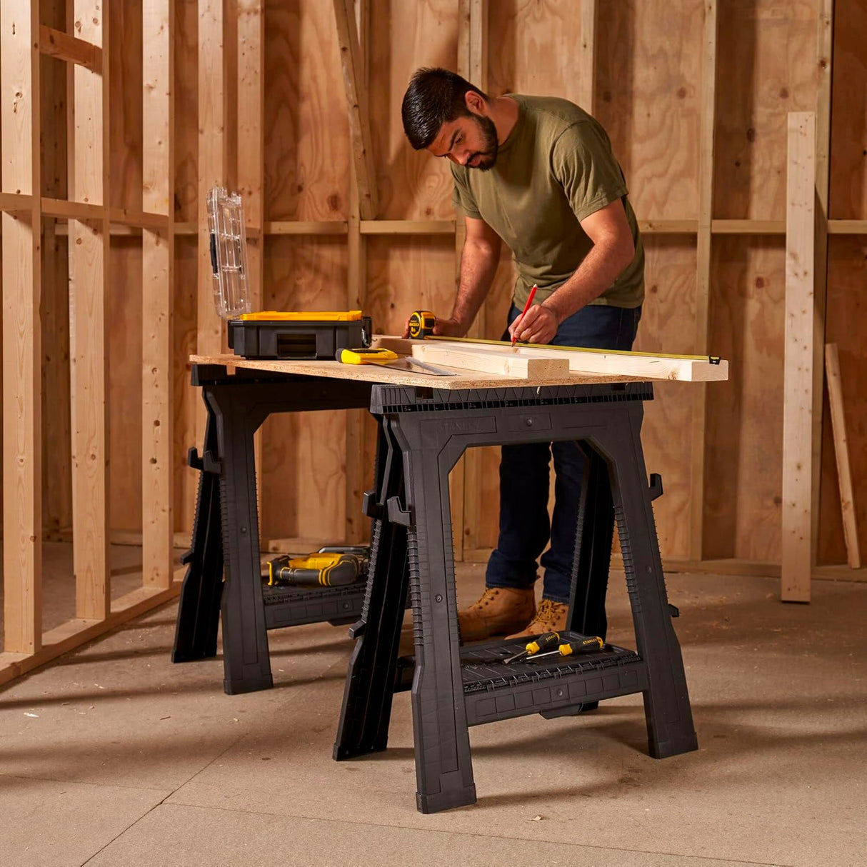 Tréteau Stanley, support d’atelier noir, utilisé pour découper du bois.