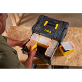 Boîte à outils noire et jaune Stanley, rangement modulaire, utilisée sur un établi.