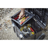 Caisse à outils Stanley noire, outils jaunes et gris, sur chantier