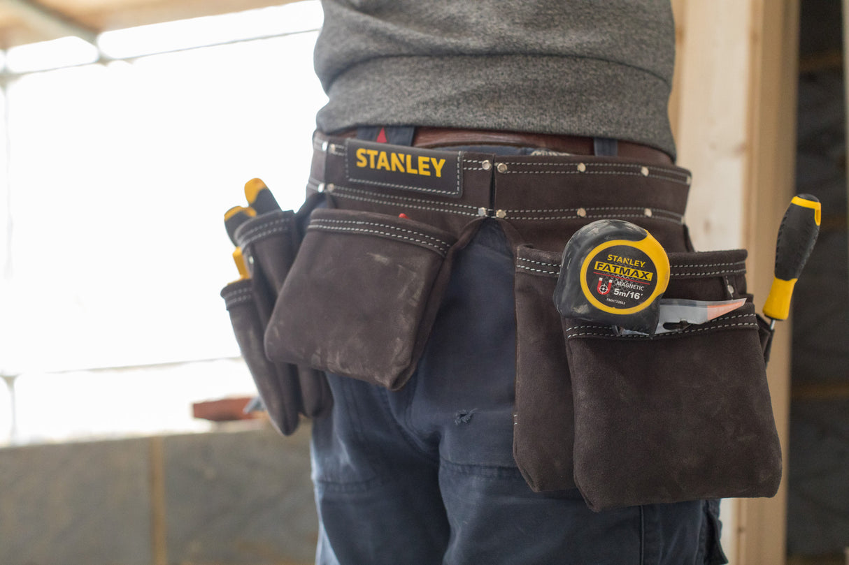 Ceinture porte-outils Stanley noire, type porte-outils de bricolage, avec outils jaunes.