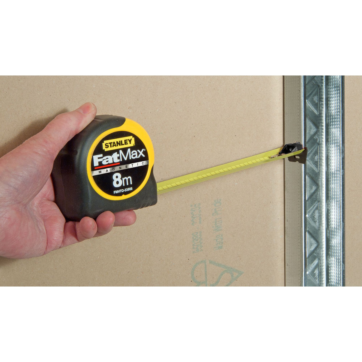 Mètre ruban Stanley FatMax jaune et noir, outil de mesure, utilisé sur chantier.