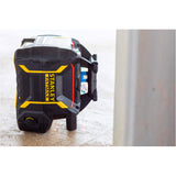 Niveau laser Stanley Fatmax noir et jaune posé au sol sur chantier