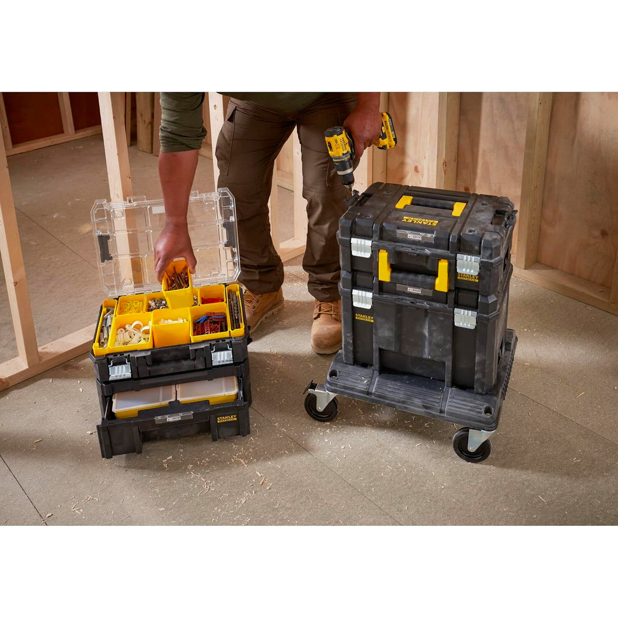 Coffre à outils Stanley modulaire noir et jaune, rangement d’outils, sur chantier.