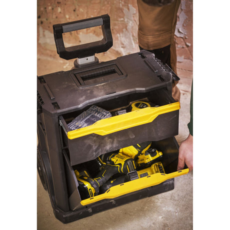 Boîte à outils Dewalt noire et jaune avec tiroirs ouverts, contenant des outils électroportatifs.