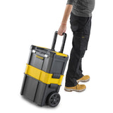 Caisse à outils Stanley, chariot noir et jaune, transportée par une personne