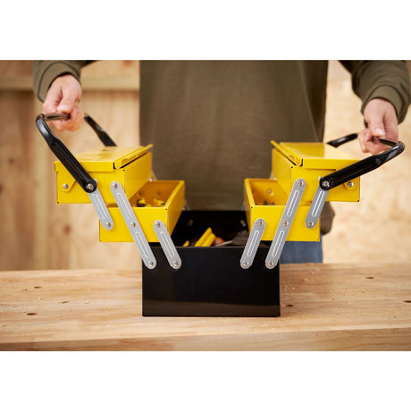 Boîte à outils Stanley, métallique, couleur jaune et noire, ouverte sur un établi