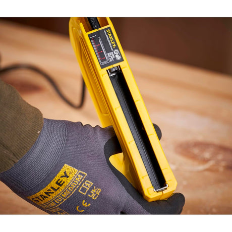 Agrafeuse électrique jaune Stanley utilisée sur établi en bois, outil électroportatif