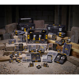 Coffrets d'embouts et forets Stanley, outillage de couleur noire et jaune, disposés sur des parpaings.