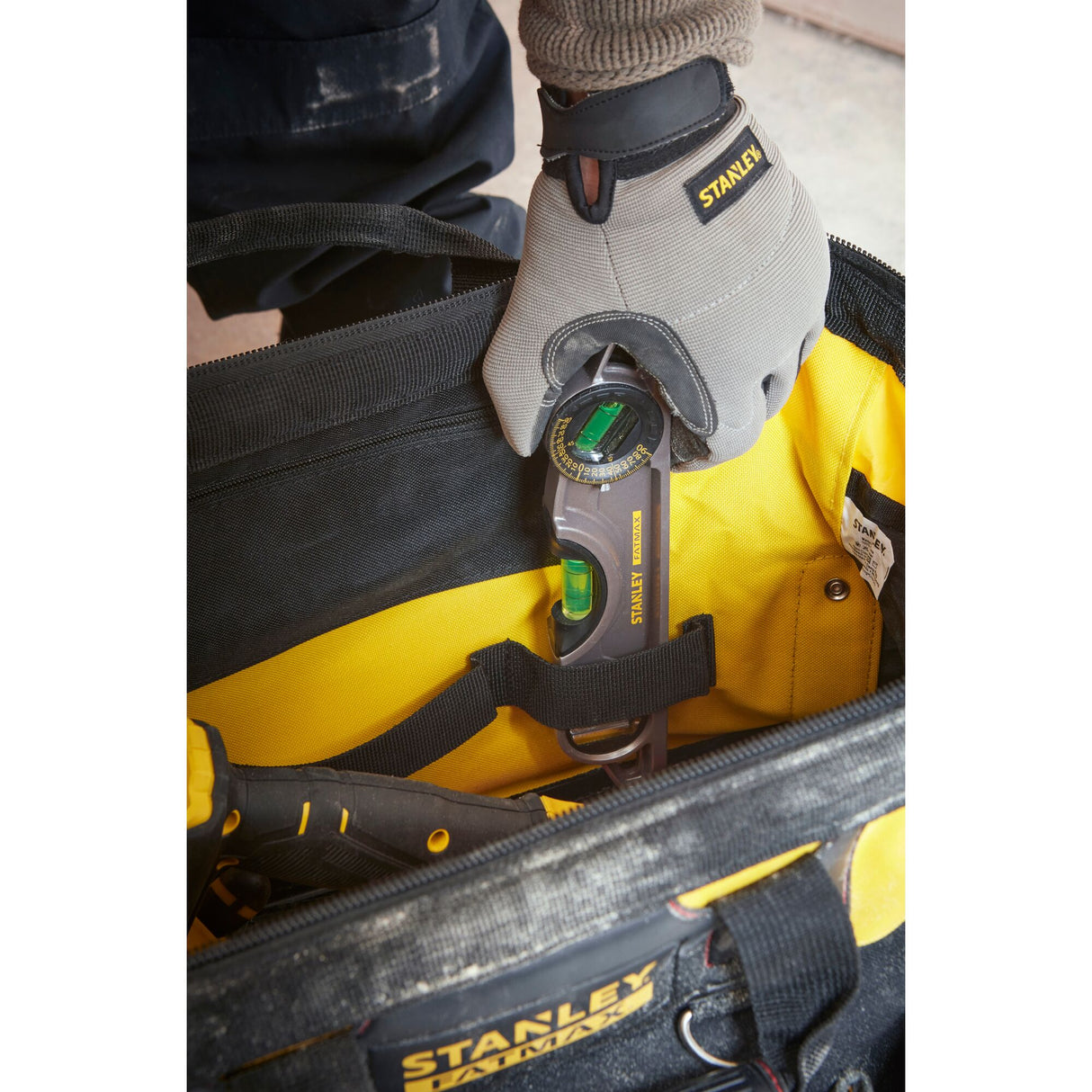 Niveau à bulle Stanley, outil gris et jaune, rangé dans un sac à outils