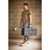 Homme portant un établi pliant noir Stanley, outillage portable, couleur noir