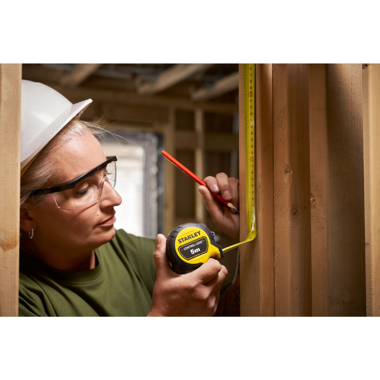 Mètre ruban Stanley jaune, outil de mesure, utilisé sur un chantier bois, couleur jaune.