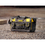 Sac à outils Stanley Fatmax, type sacoche, noir et jaune, posé sur sol humide