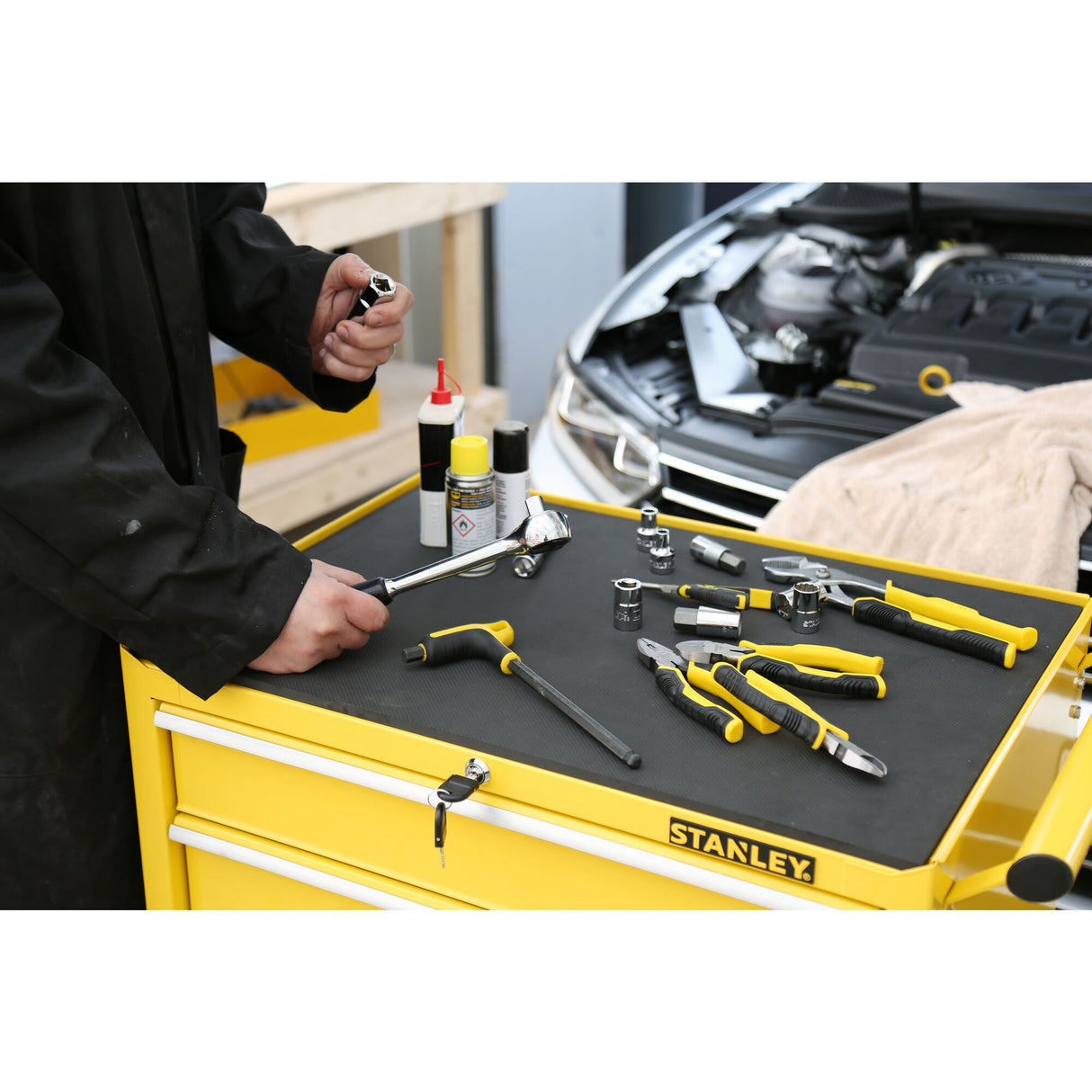 Servante d’atelier Stanley jaune avec outils à main noirs et jaunes, marque Stanley visible.