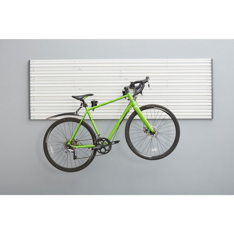 Support mural blanc pour vélo, marque Gladiator, type rangement, exposé avec un vélo vert.