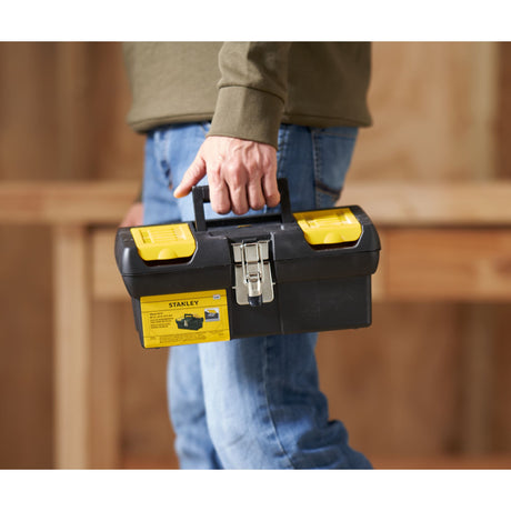 Boîte à outils Stanley noire et jaune, portée à la main, idéale pour bricolage.