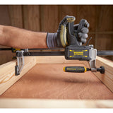 Presse à serrer noire et jaune Stanley FATMAX utilisée pour menuiserie sur bois clair