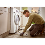 Hommes utilisant un leve-meuble Facom, type outillage, couleur noire et jaune, sous une machine à laver.