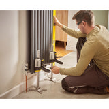 Homme utilisant des serre-joints gris Stanley pour installer un radiateur gris.