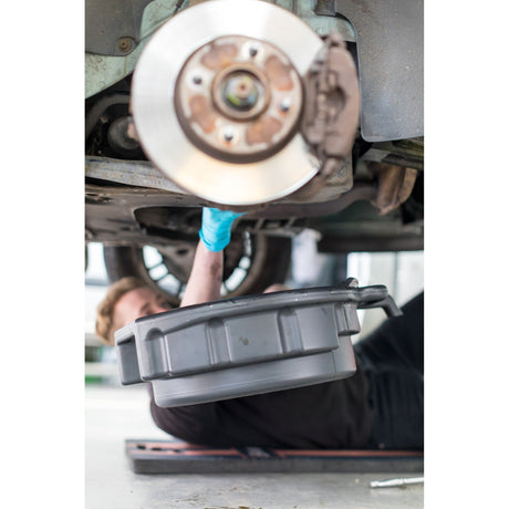 Bac de vidange Facom, récipient gris utilisé sous une voiture pour vidange d'huile.
