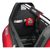 Mètre ruban Facom rouge, outil de mesure placé dans un sac à outils noir et rouge.