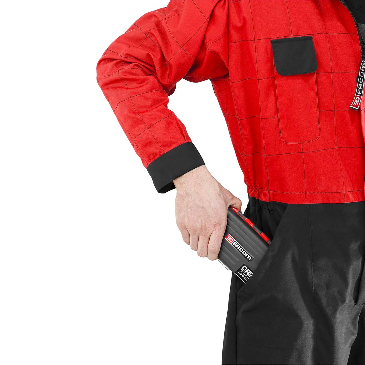 Batterie Facom outil noir et rouge, insérée dans la poche d'une combinaison rouge.