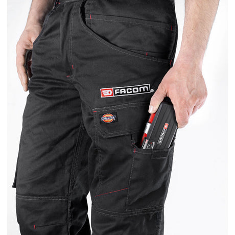 Pantalon de travail noir Facom, outil Facom dans la poche, marquage visible.