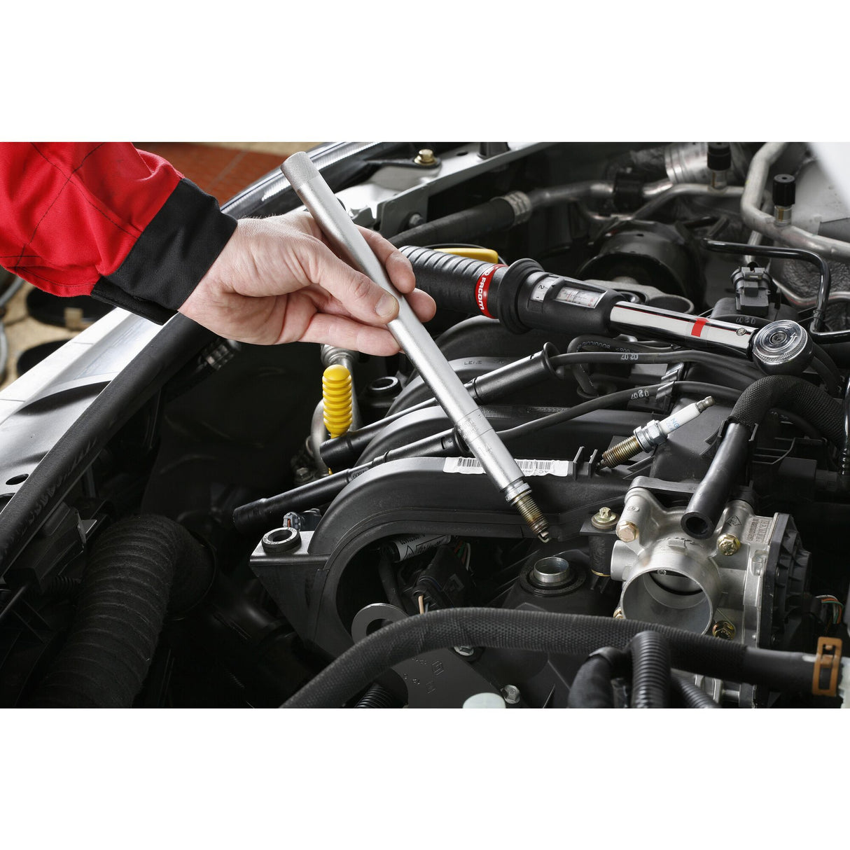 Bougie d’allumage Facom, outillage auto, couleur argent, en utilisation dans un moteur