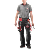Homme portant une ceinture porte-outils Facom noire et rouge avec outils, pantalon noir, polo gris.