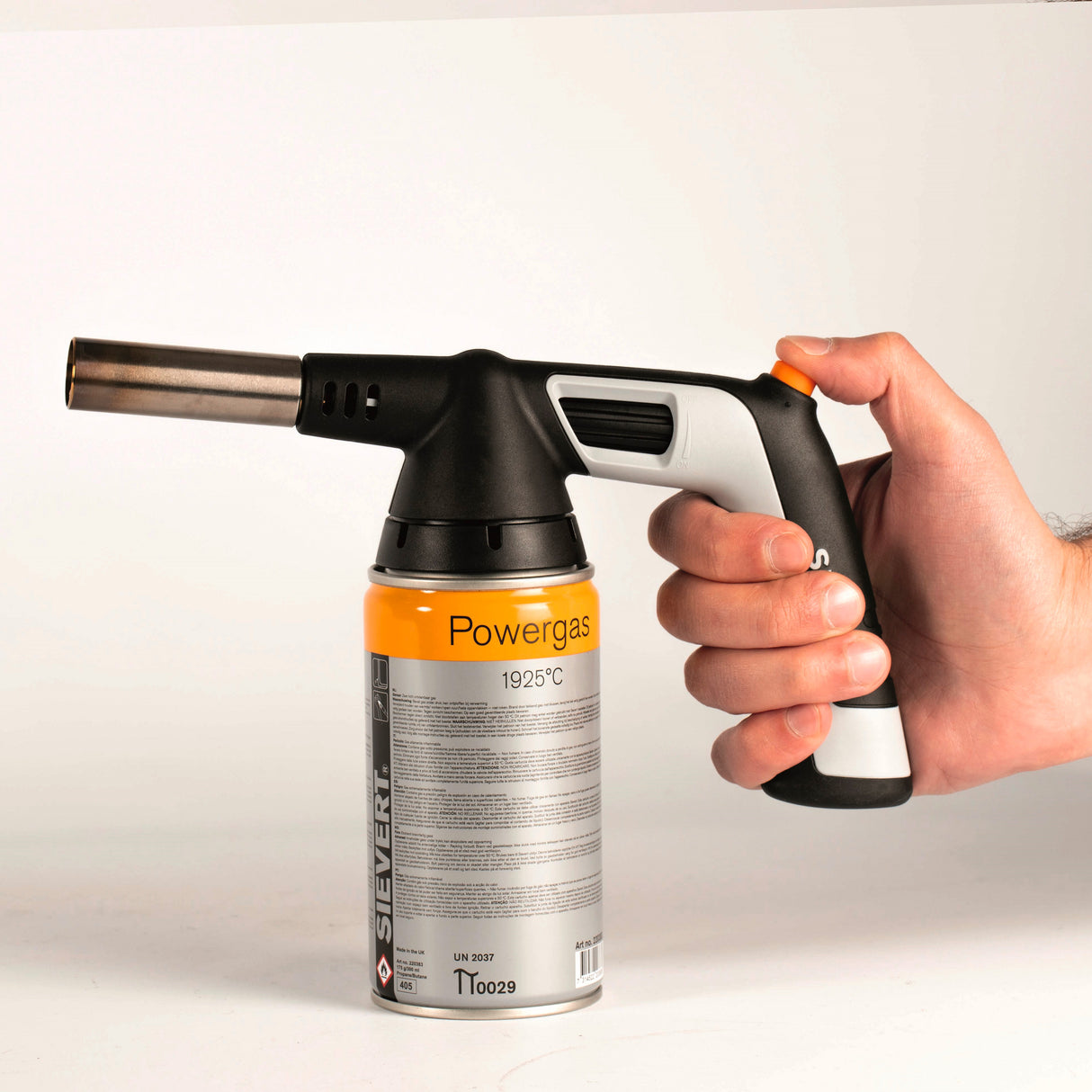 Chalumeau à gaz Sievert noir et gris avec cartouche Powergas jaune, tenu en main.