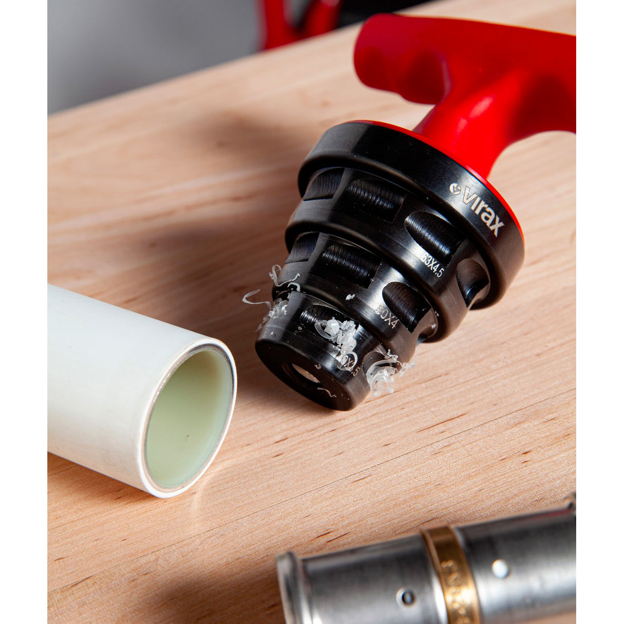 Outil chanfreineur Virax, type plomberie, couleur rouge et noir, sur table bois