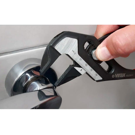 Clé à molette Virax noire, outil réglable utilisé sur un robinet chromé