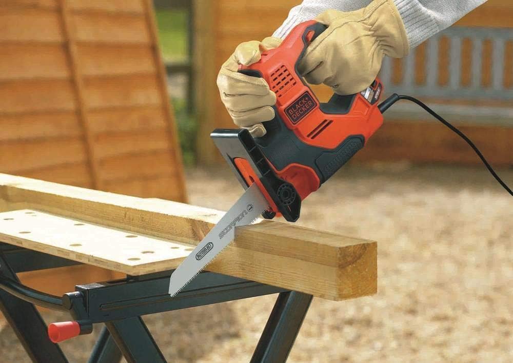 Scie sabre Black+Decker, outil électroportatif, couleur orange et noir, en action sur bois.