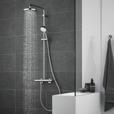 Douche Grohe, colonne de douche chromée, couleur argent, moderne sur carrelage gris.