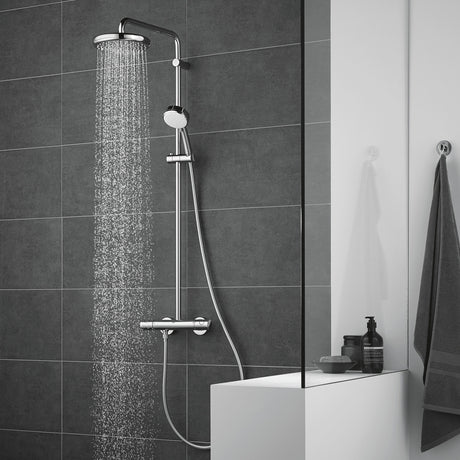 Douche Grohe, colonne de douche chromée, couleur argent, moderne sur carrelage gris.