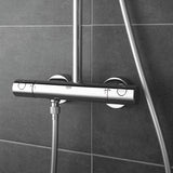 Mitigeur thermostatique de douche Grohe, chromé, fixé sur carrelage gris.