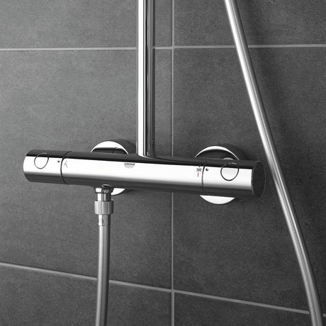 Mitigeur thermostatique de douche Grohe, chromé, fixé sur carrelage gris.