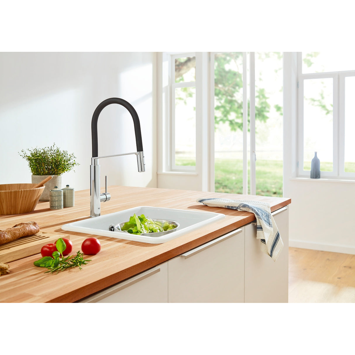 Mitigeur cuisine Grohe noir et chromé, robinet moderne posé sur évier blanc