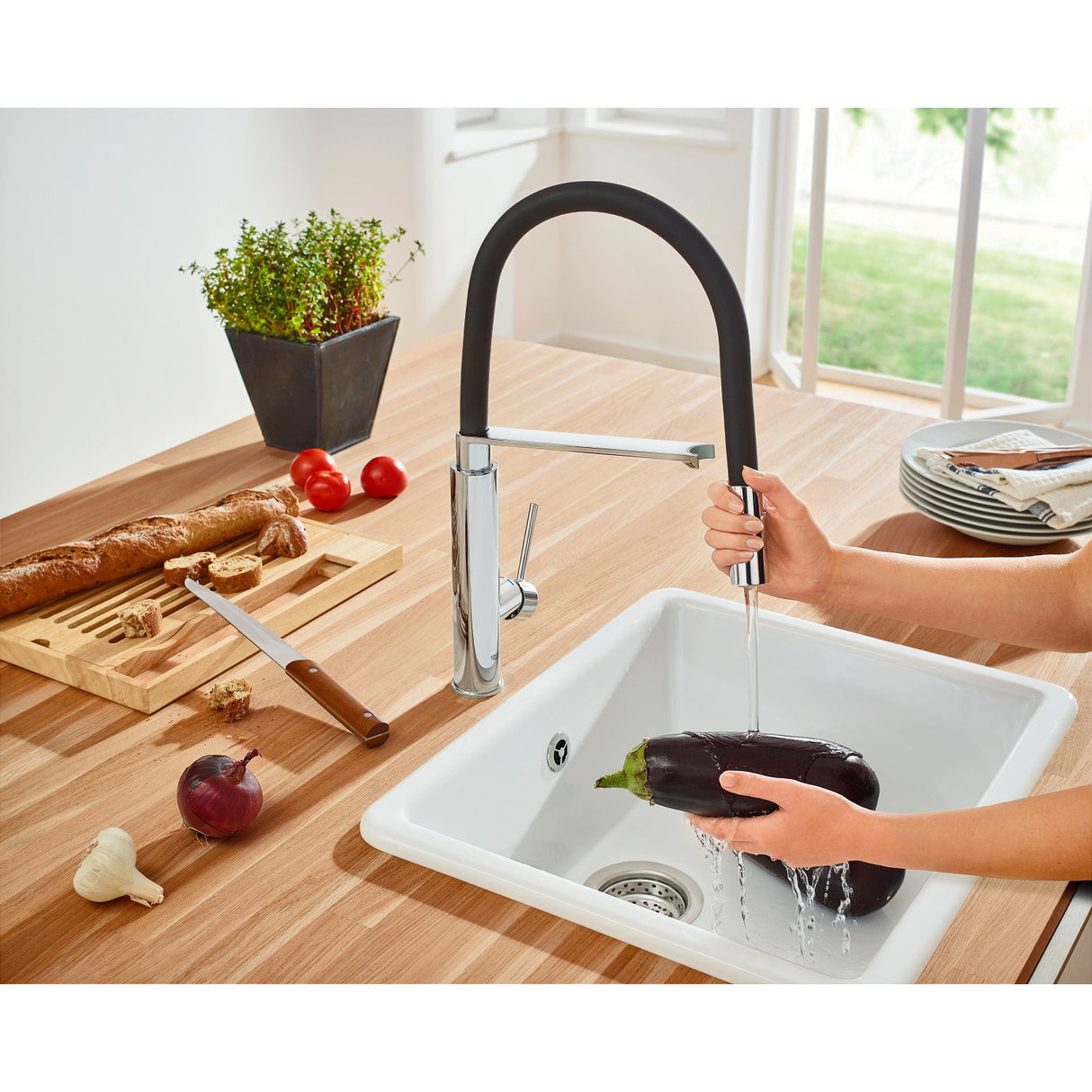Mitigeur de cuisine Grohe, robinet noir et chromé, utilisé pour laver une aubergine