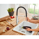 Mitigeur de cuisine Grohe, robinet noir et chromé, utilisé pour laver une aubergine