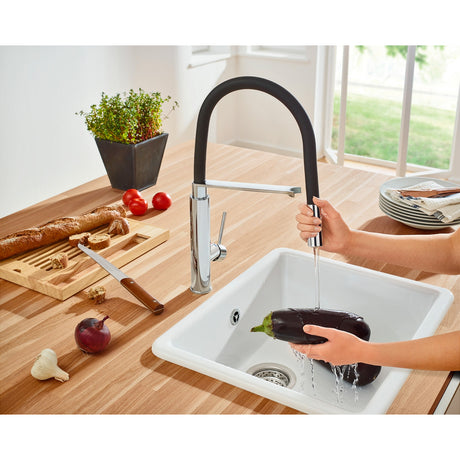 Mitigeur de cuisine Grohe, robinet noir et chromé, utilisé pour laver une aubergine