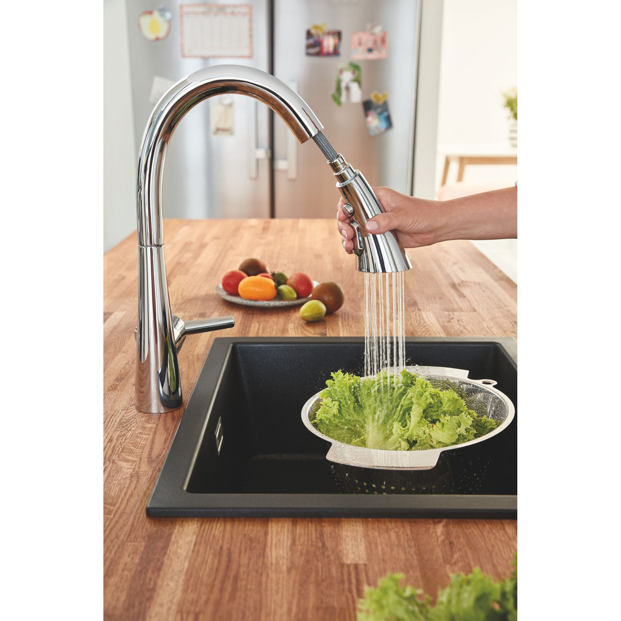 Mitigeur de cuisine Grohe, chromé, avec douchette, utilisé pour laver une salade.