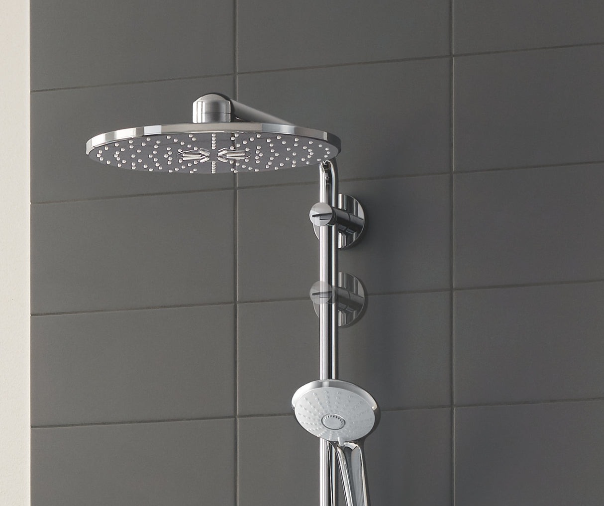 Douche Grohe, colonne de douche en inox, couleur chrome, sur carrelage gris.