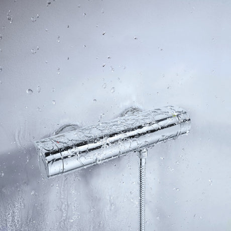 Mitigeur de douche Grohe, thermostatique, couleur chromée, avec effet d'eau sur fond blanc.