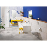 Salle de bain Grohe moderne avec baignoire blanche, meuble vasque jaune et murs bleus.