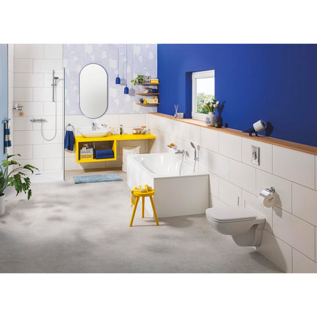 Salle de bain Grohe moderne avec baignoire blanche, meuble vasque jaune et murs bleus.