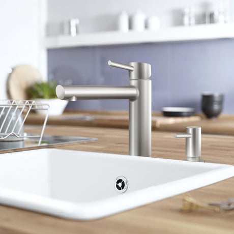 Mitigeur de cuisine Grohe, robinet inox argenté, design moderne sur évier blanc.