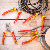 Jeu de pinces Stanley FATMAX, outillage à main, rouge et jaune, sur table en bois.